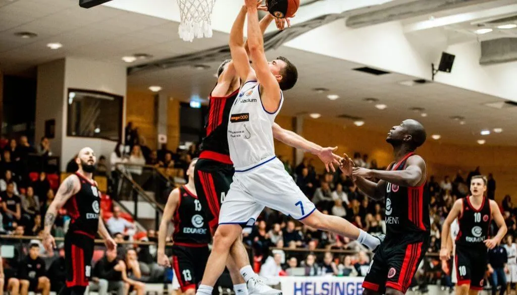 T4Q:s herrlag i en match, en spelare hoppar mot korgen